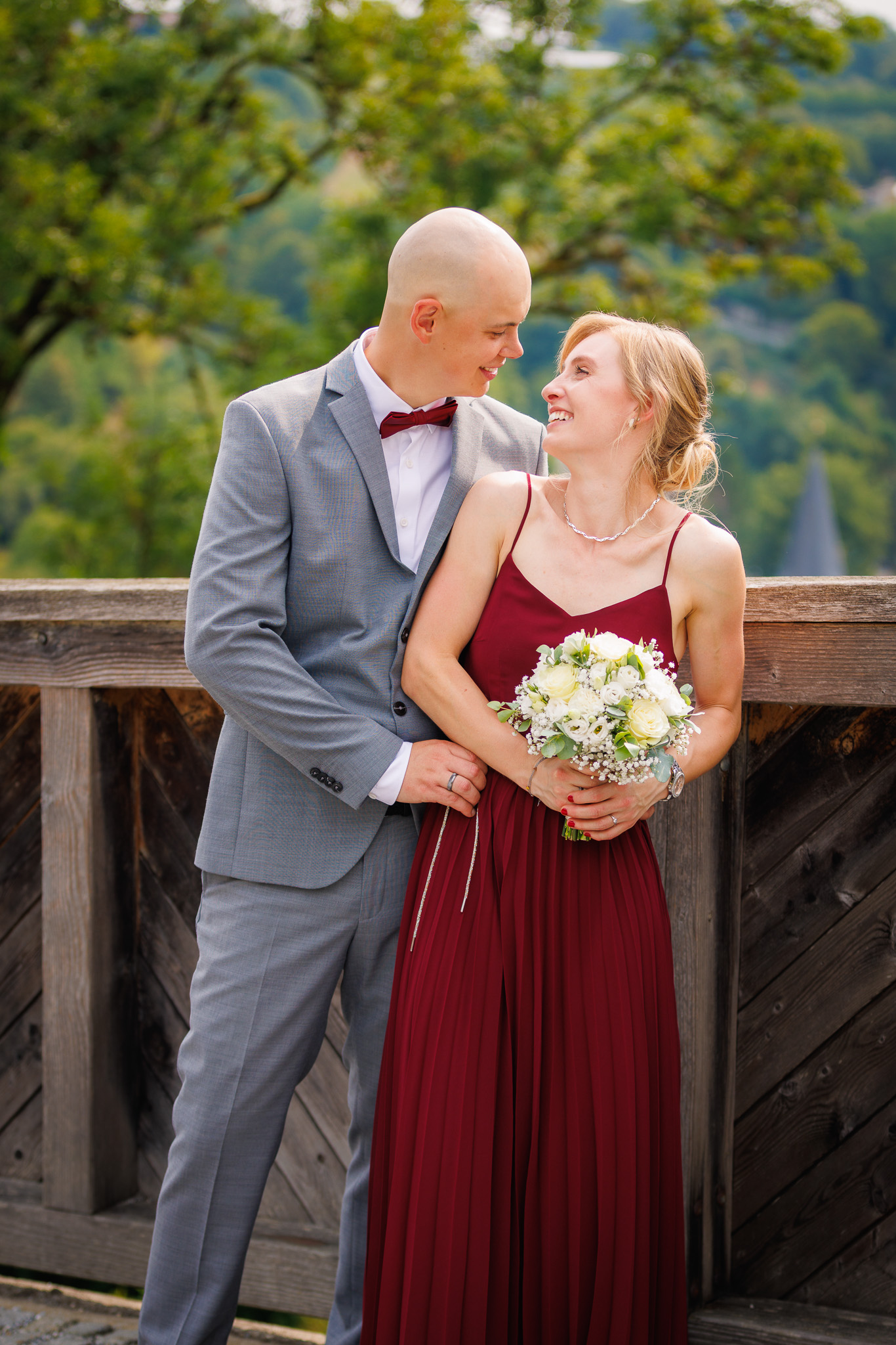 Brautpaar lächelt sich fröhlich an. Hochzeitsfotografie.