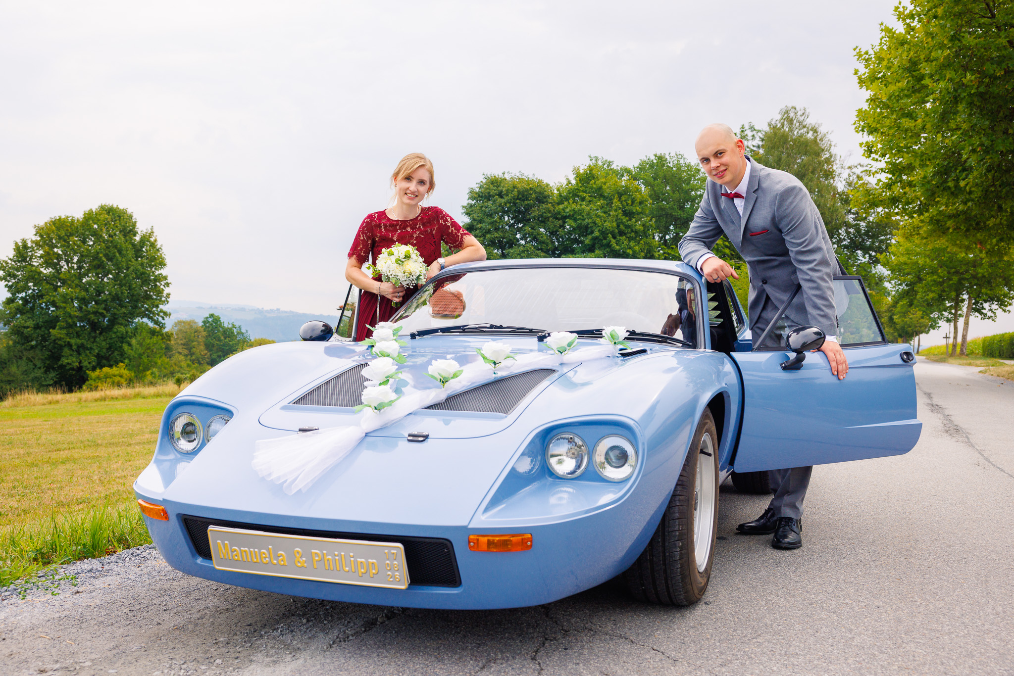 Brautpaar posiert am Hochzeitsauto - Brautpaarshooting